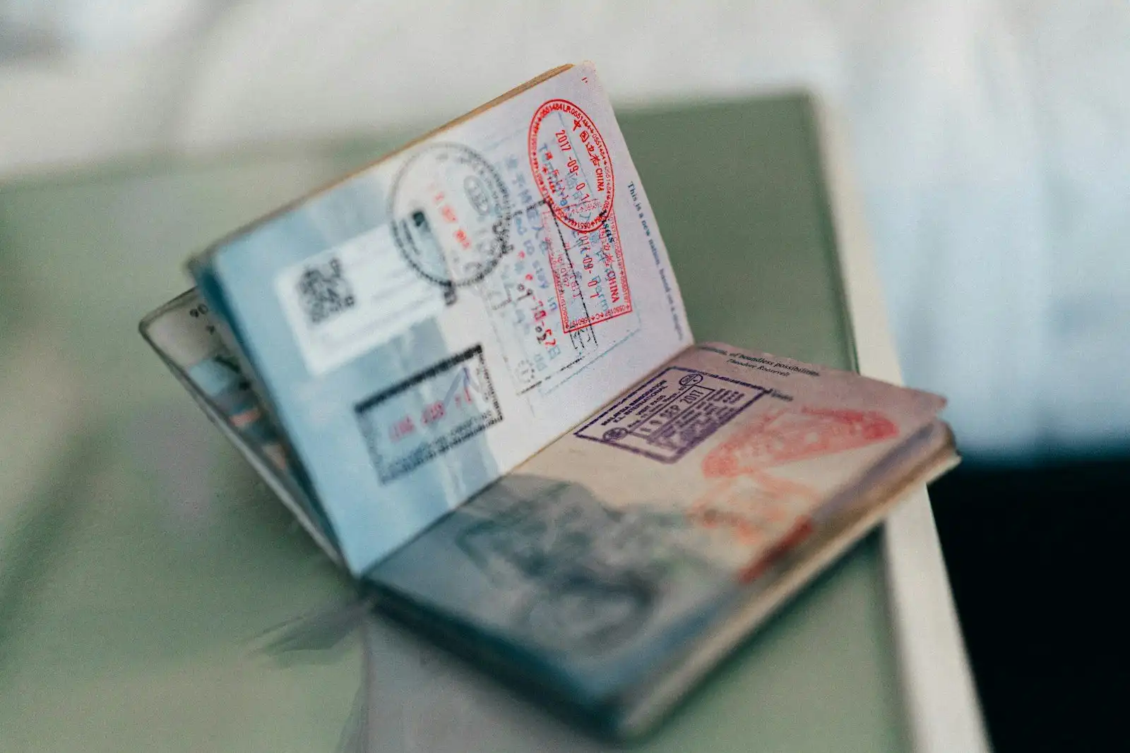 An open passport with entry stamps from several countries